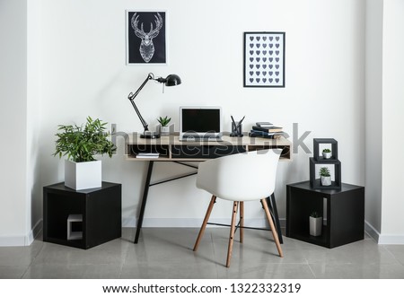 Stylish workplace with laptop in room Royalty-Free Stock Photo #1322332319
