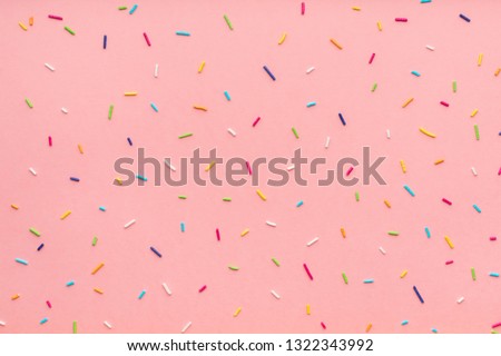trendy pattern of colorful sprinkles for background of design banner, poster, flyer, card, postcard, cover, brochure over pink 