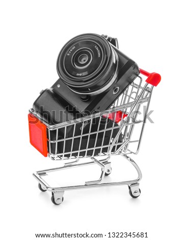 Photo camera in shopping cart isolated on white background