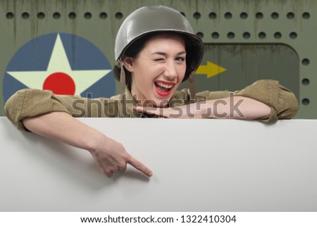 young woman dressed in wwii military uniform with helmet showing empty blank signboard with a copy space