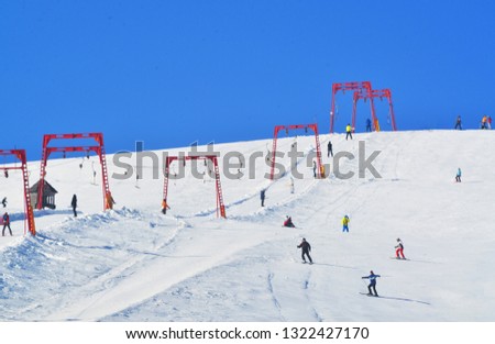 Skiing resort in the mountains, winter sports and recreation concept, skiers and snowboarders on the ski lift