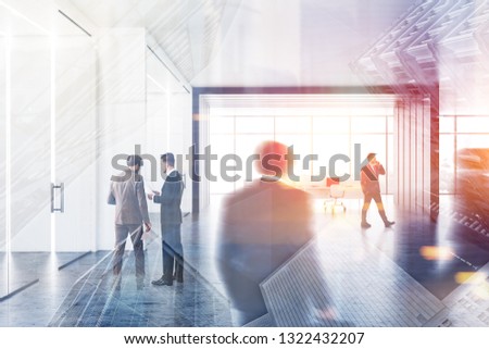 Businessment in office lobby with white and gray walls, concrete floor, glass doors and open space office area with white computer tables near panoramic window. Toned image double expousre blur