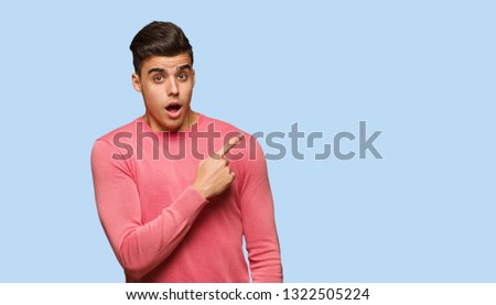Young funny man pointing to the side