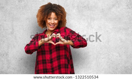 Young black afro woman doing a heart shape with hands