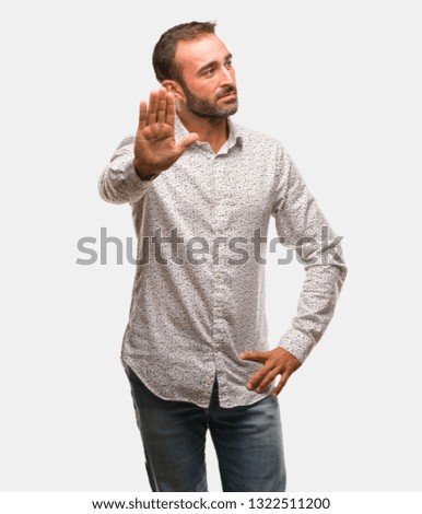 Caucasian man on grey brackground putting hand in front