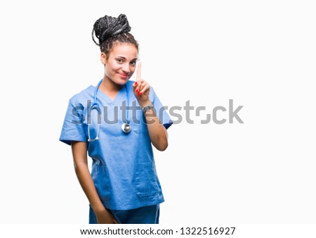 Young braided hair african american girl professional surgeon over isolated background showing and pointing up with finger number one while smiling confident and happy.