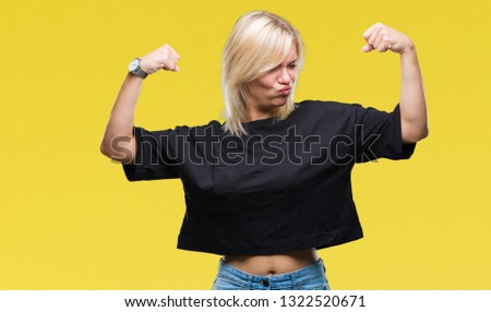 Young beautiful blonde woman over isolated background showing arms muscles smiling proud. Fitness concept.