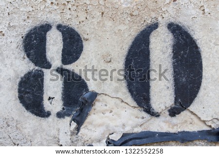 number eighty painted stencil on concrete wall, number 80