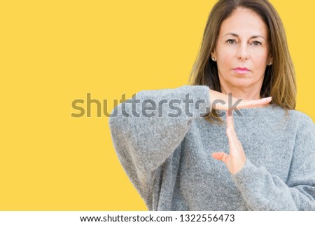 Beautiful middle age woman wearing winter sweater over isolated background Doing time out gesture with hands, frustrated and serious face