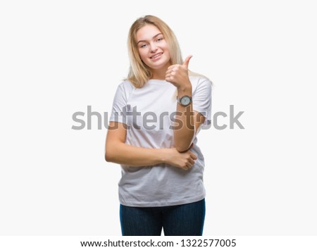 Young caucasian woman over isolated background doing happy thumbs up gesture with hand. Approving expression looking at the camera with showing success.