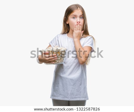 Young beautiful girl eating popcorn snack isolated background cover mouth with hand shocked with shame for mistake, expression of fear, scared in silence, secret concept
