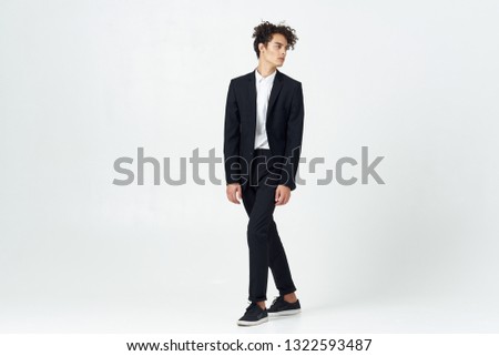 Cute elegant man in a suit on a gray isolated background office worker