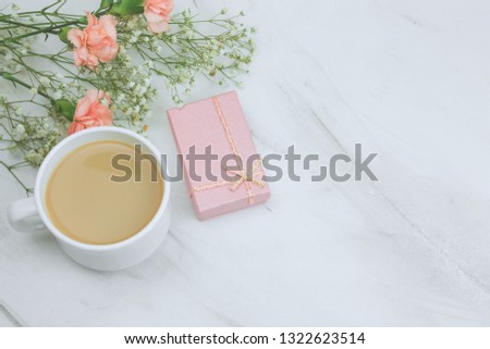 top view carnation flowers,cup of drink and  and pink gift box  on a marble background copy space 