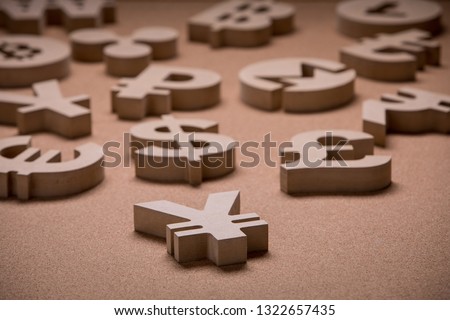 Wooden Symbols of World Currencies in Group Picture with Shallow Focus with Yen or Yuan Sign in the Front