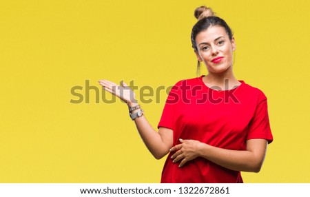 Young beautiful woman over isolated background smiling cheerful presenting and pointing with palm of hand looking at the camera.