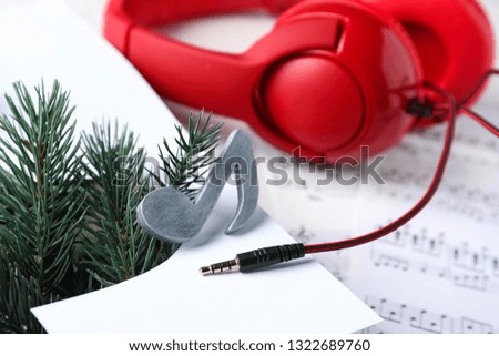 Music note sign and headphones on table, closeup
