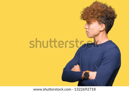 Young handsome man with afro hair smiling looking to the side with arms crossed convinced and confident