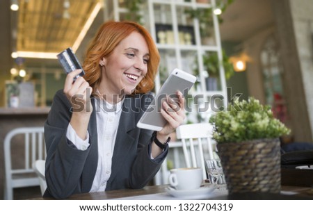 Portrait of a happy shopper paying on line with credit card in a bar - Image
