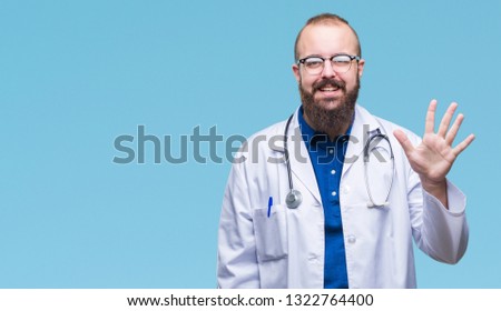 Young caucasian doctor man wearing medical white coat over isolated background showing and pointing up with fingers number five while smiling confident and happy.