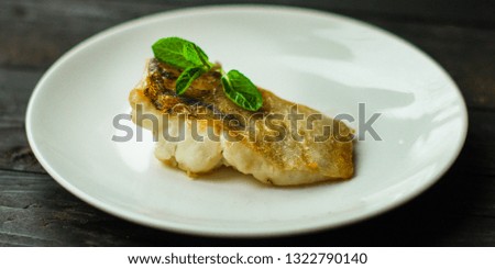 Fish, fried seafood (white fish on the plate). Food background