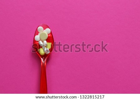Pharmaceutical medicine pills, tablets and capsules on plastic spoon. 