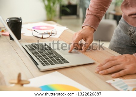 Young designer with laptop working in office