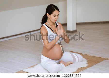 Pregnant woman practice yoga in domestic room at home. Practicing healthy lifestyle. Fitness for future Moms.