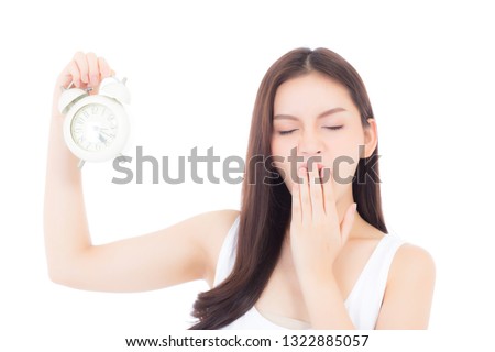 Beautiful portrait young asian woman yawn resting with sleepy isolated on white background, girl wake up holding alarm clock with tired and bored in morning, time and relax concept.