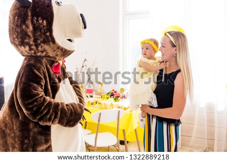 Actor in a bear costume congratulates a girl and her family on her birthday