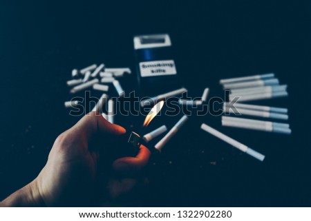 Broken cigarettes. Dangerous habit. Harmful for health. Smoking stop. Man holds lighter in hands.