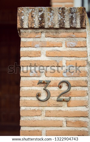 House number thirty two (32) on a brick wall - Image