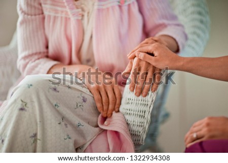 Young nurse comforting an elderly woman