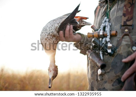 Duck hunter holding a freshly killed duck.
