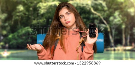 Hiker girl upset with a broken phone at outdoors