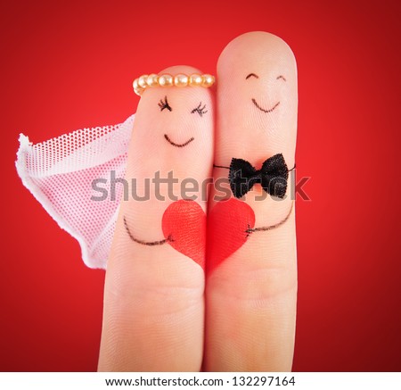 wedding concept - newlyweds painted at fingers against red background Royalty-Free Stock Photo #132297164