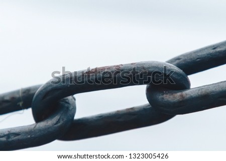 The chain hangs on the fence of the river early