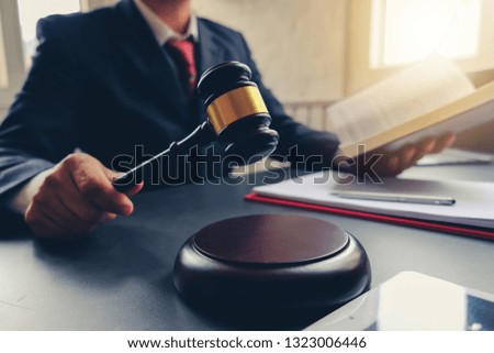 The lawyer working in the office and holding the auction hammer. Law and justice concept.