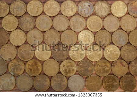 Golden coins of five dinars are correctly sorted on a wooden table