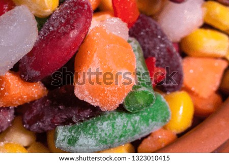 Homemade mixture of frozen vegetables, macro close-up background. Carrot, paprika, beans, green beans, onion and corn.