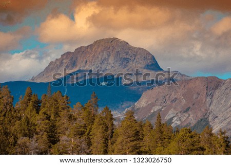 Beautiful autumn nature of Norway. Fir trees against mountains at sunset