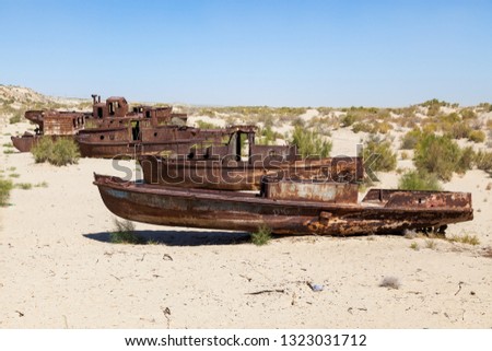 Rustic boats on a ship graveyards on a desert around Moynaq, Moynoq or Muynak - Aral sea or Aral lake - Uzbekistan, Central Asia Royalty-Free Stock Photo #1323031712