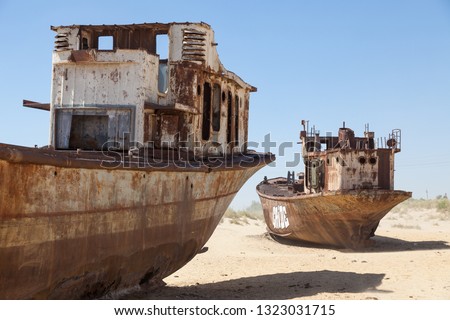 Rustic boats on a ship graveyards on a desert around Moynaq, Moynoq or Muynak - Aral sea or Aral lake - Uzbekistan, Central Asia Royalty-Free Stock Photo #1323031715
