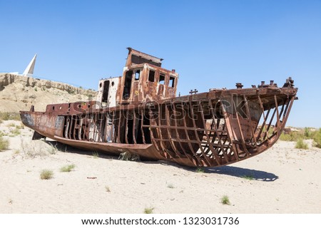 Rustic boats on a ship graveyards on a desert around Moynaq, Moynoq or Muynak - Aral sea or Aral lake - Uzbekistan, Central Asia Royalty-Free Stock Photo #1323031736