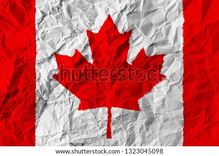 Canada flag on paper. The crumpled flag is a red maple leaf.