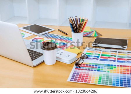 Graphic designer object tool and color swatch samples at workspace.