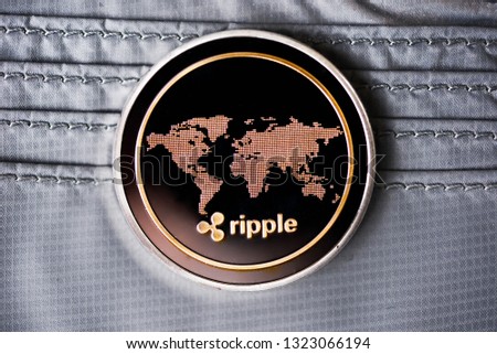 Golden ripple coin. Crypto XRP Coin on dark wood background and wallet. Close-up, macro shot.New Virtual Money 