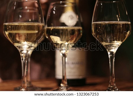 Champagne in glasses blurred, gold and isolated. Girls night out, holiday, celebration in bar with alcohol and splashes of champagne in glasses.