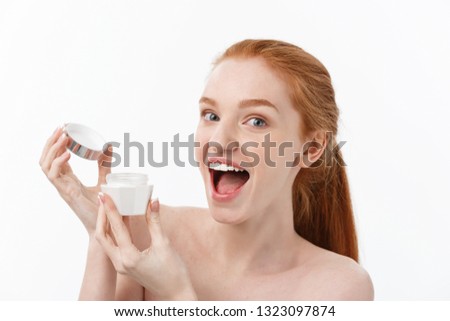 portrait of beautiful woman smiling while taking some facial cream isolated on white background with copy space.