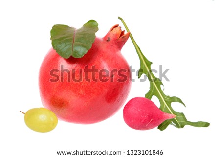 Minimalistic still life with unexpected combination of red pomegranate fruit, pink radish, fresh chard, arugula green leaf and grape berry isolated on white background. Ingredients for salad