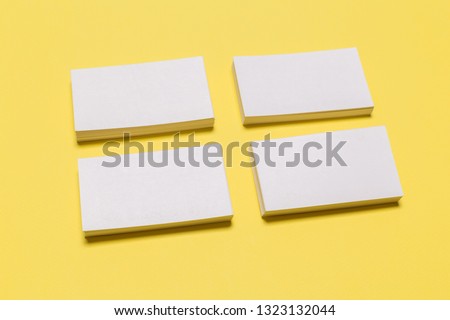 Blank white business cards on yellow background. Mockup for branding identity. Template for graphic designers portfolios. Top view. 